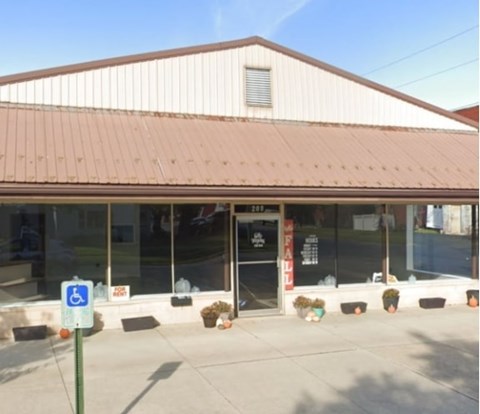 A building with a brown roof and a handicap parking sign in front.