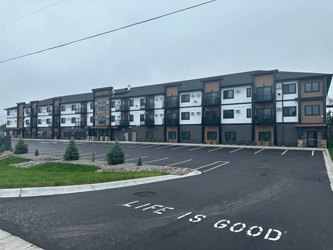 A parking lot with the words "Life is Good" painted on the pavement.
