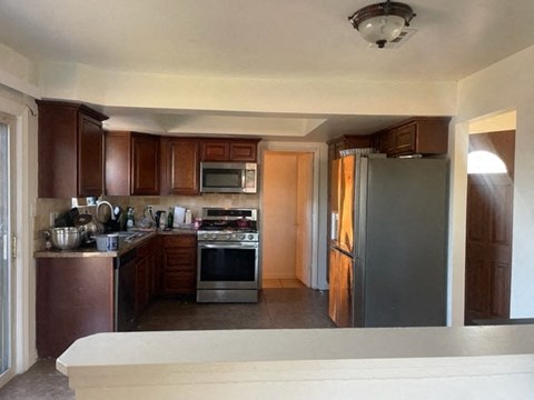 A kitchen with brown cabinets and a stove top oven.