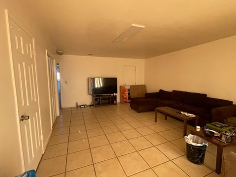 A living room with a brown couch and a television.