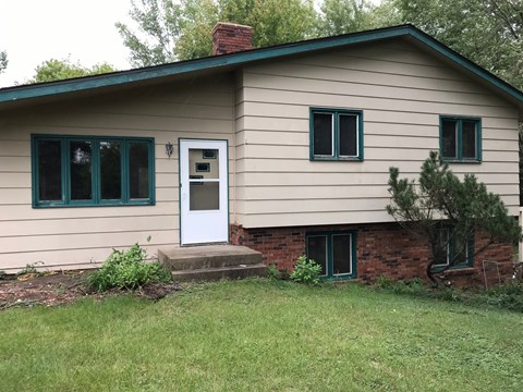 A house with a white door and green windows.