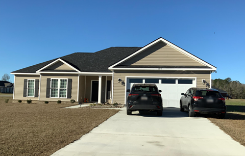 A house with two cars parked in front.