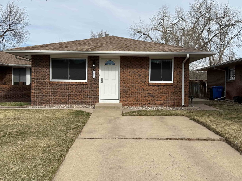 A brick house with a white door and a small porch.