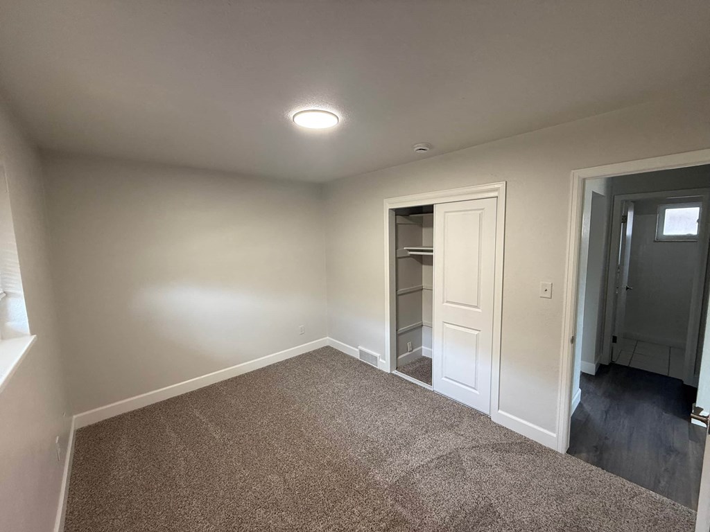 A room with a carpeted floor and a single door.