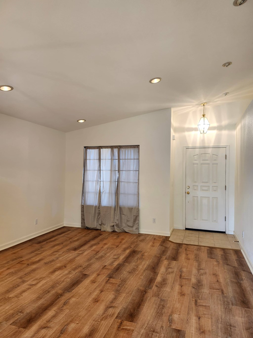 A room with wooden flooring and a white door.