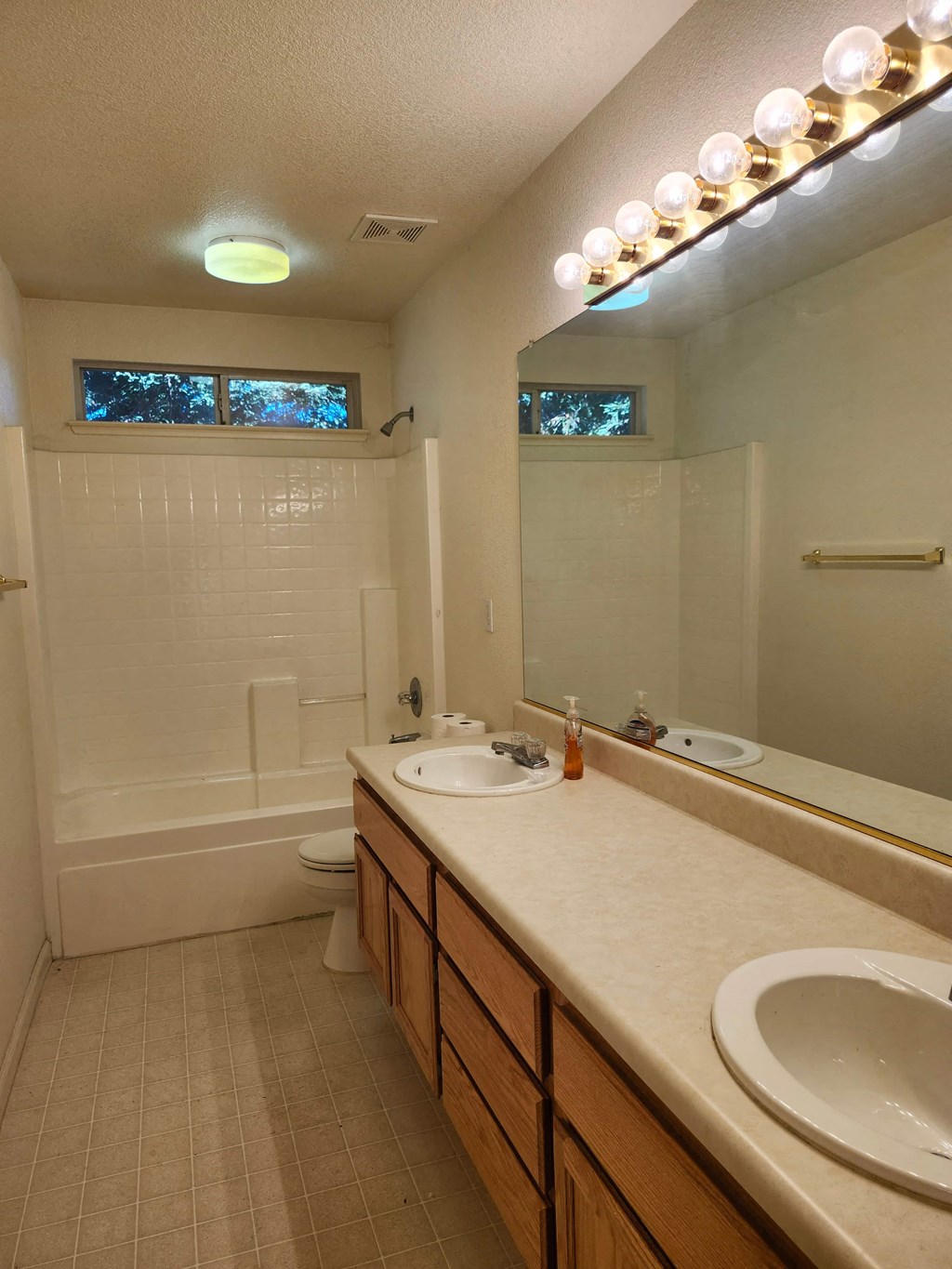 A bathroom with a sink, mirror, and lights.