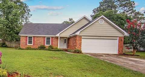 A house with a red brick wall and a white garage door.