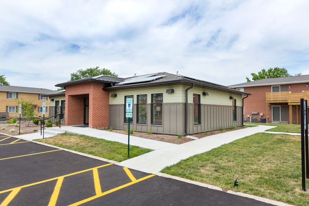 A parking lot in front of a building with a yellow line painted on the pavement.
