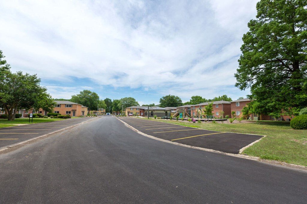 A road in a residential area with houses on both sides.
