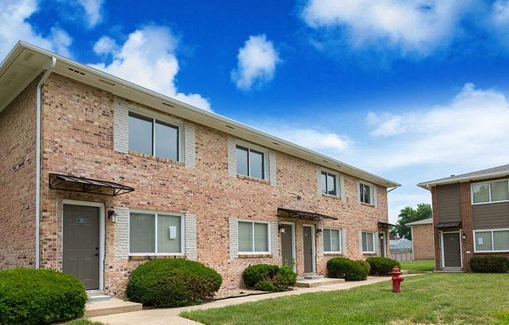 A row of houses with a red fire hydrant in front of them.