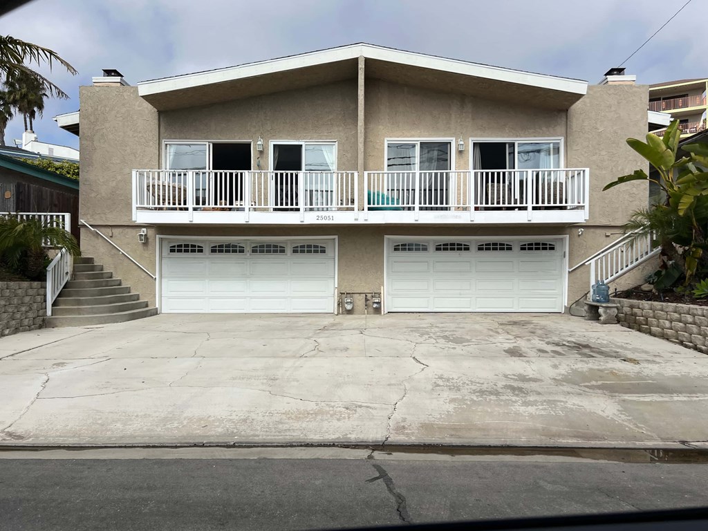 A two-story house with a balcony on the second floor.