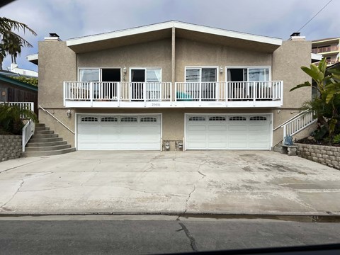 A two-story house with a balcony on the second floor.