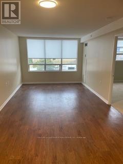 A room with wooden flooring and a window with blinds.