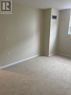 A room with a carpeted floor and a doorway.