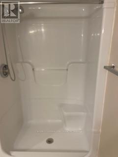 A white shower stall with a door open.