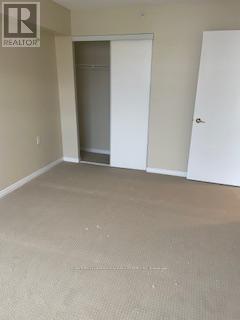 A room with a carpeted floor and two doors, one of which is open.