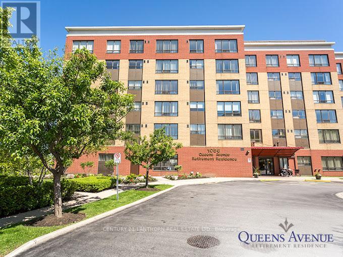 A large brick building with a sign that says Queens Avenue in front of it.