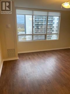 A room with a window overlooking a building with a sign that says REALTOR.