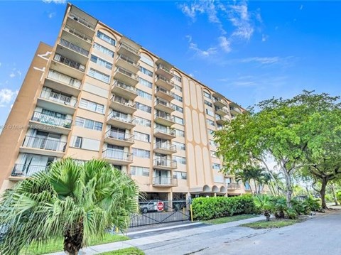 A tall apartment building with a red stop sign in front.