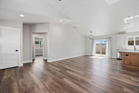 A spacious room with wooden flooring and white walls.