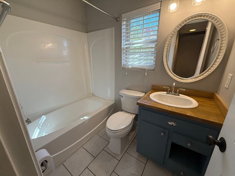 A bathroom with a white tub, toilet, and sink.