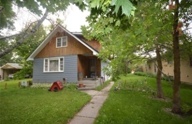 A blue house with a red object in front of it.