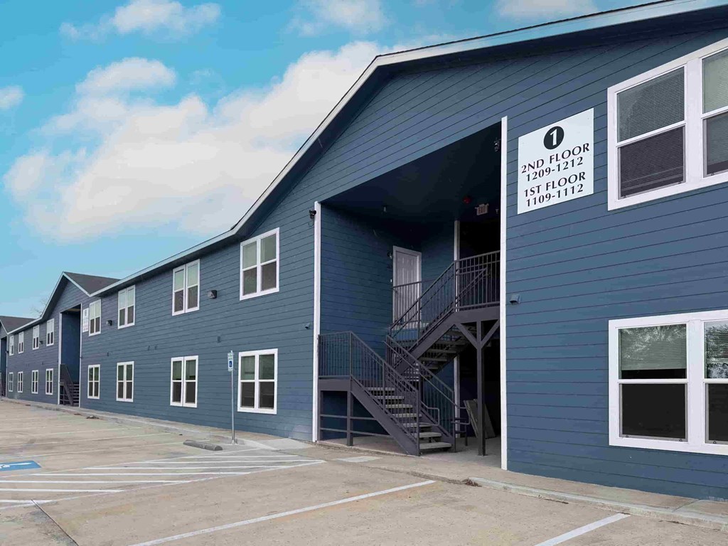 A blue building with a sign indicating the 2nd floor is from 1209-1212 and the 1st floor is from 1109-1112.