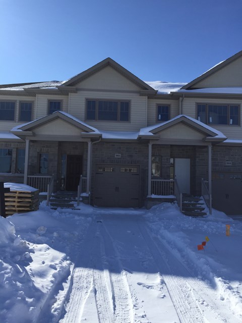 A house with a snow-covered front yard.