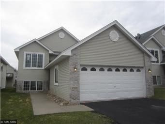 A house with a grey roof and a white garage door.