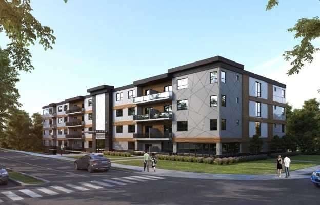 A modern apartment building with balconies and a street in front.