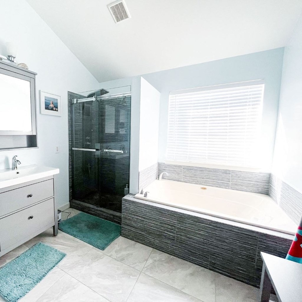 A bathroom with a white tub and a glass shower.