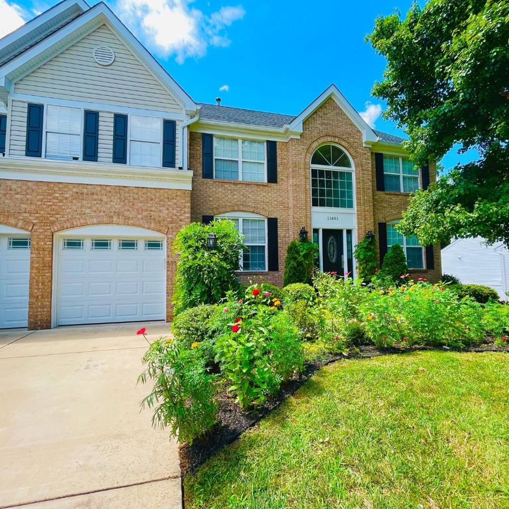 A house with a white garage door and a brick facade.