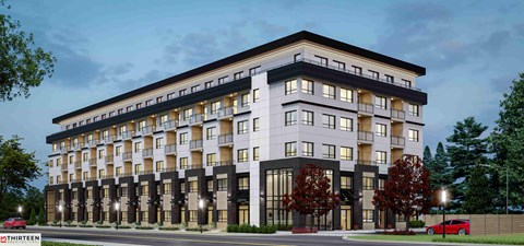 A modern multi-story building with balconies and large windows.