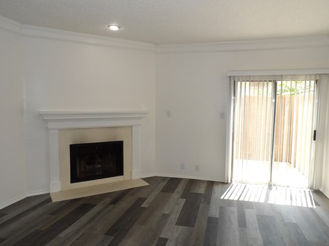 A room with a fireplace and sliding glass doors.