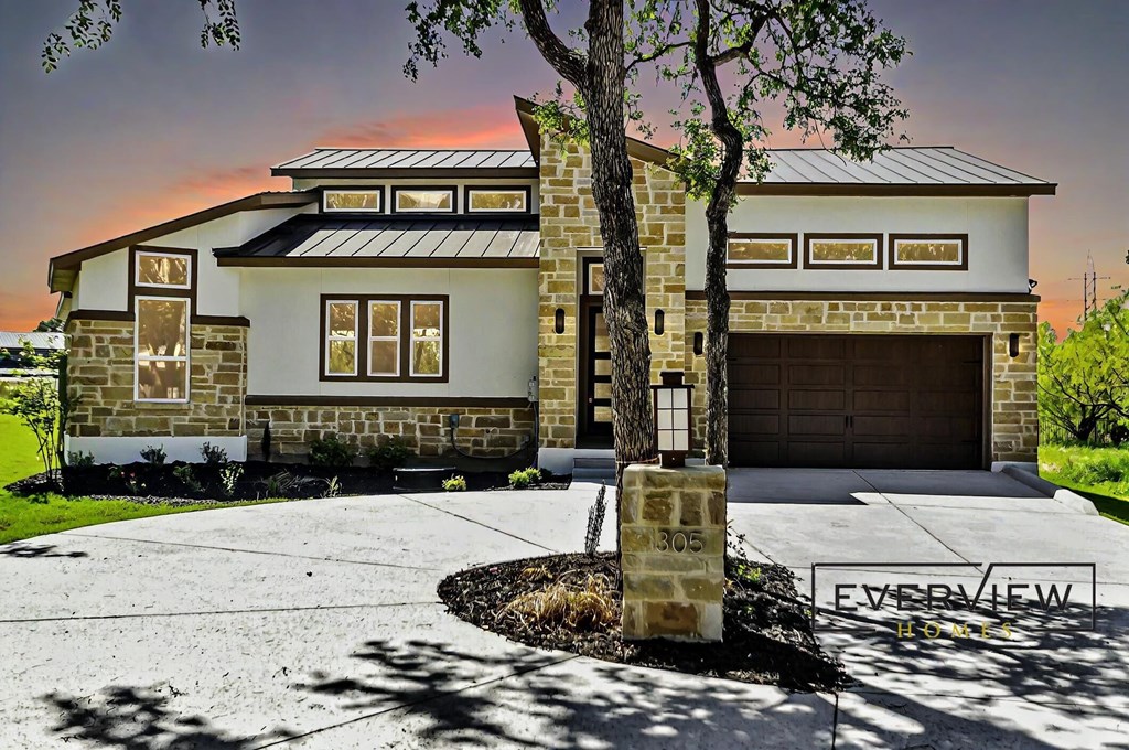 A house with a stone facade and a garage door is shown.