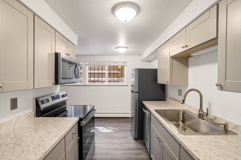 A kitchen with a black refrigerator, stove, and oven.
