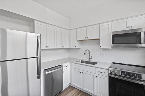 A kitchen with white cabinets and appliances.
