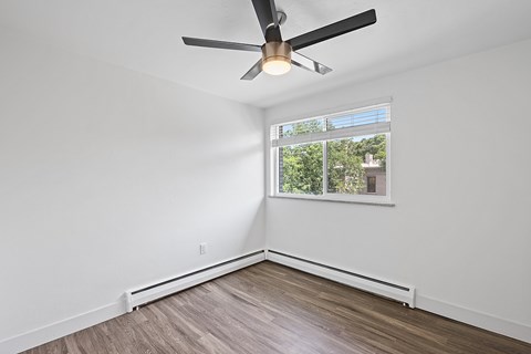 A room with a ceiling fan and a window.
