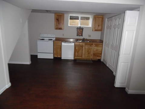 A kitchen with white appliances and wooden cabinets.