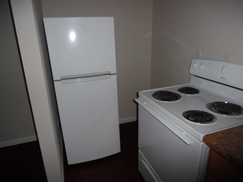 A white refrigerator and stove in a small kitchen.