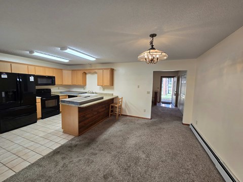 A kitchen with black appliances and a wooden island.
