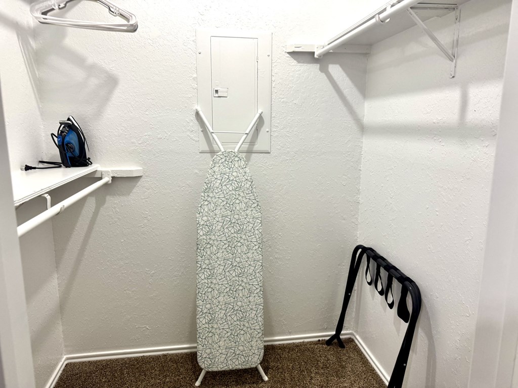 A white closet with a dress hanging in the middle.
