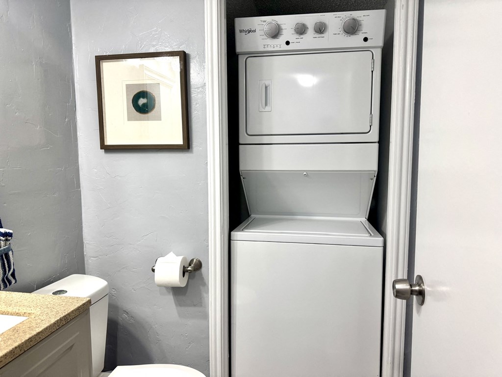 A white oven is in a bathroom next to a toilet.