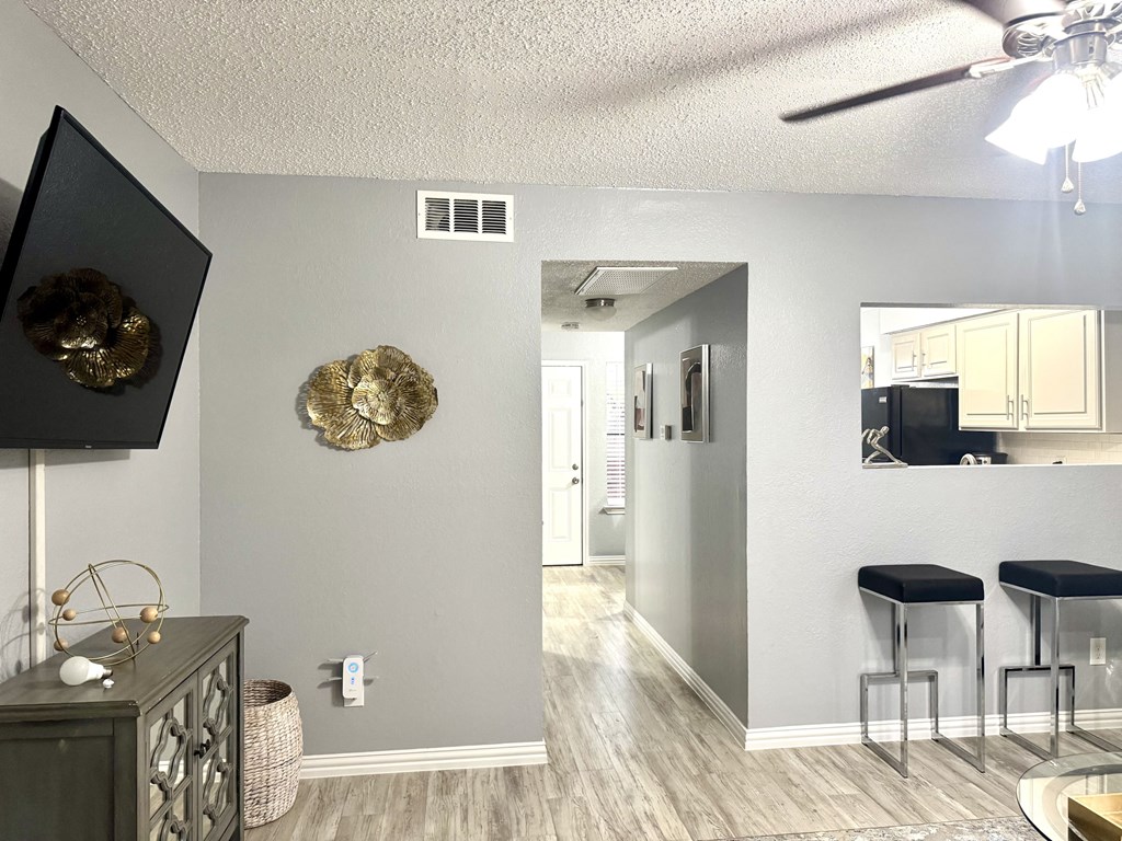 A room with a ceiling fan and a mirror on the wall.