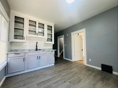 A kitchen with white cabinets and a marble countertop.