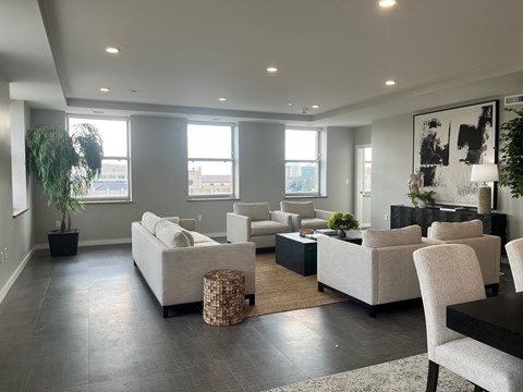 A living room with a grey floor and white furniture.
