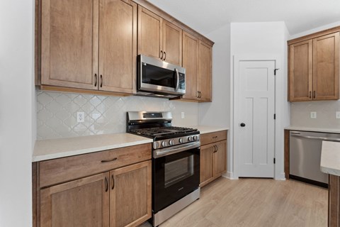 A kitchen with wooden cabinets and a black stove top oven.