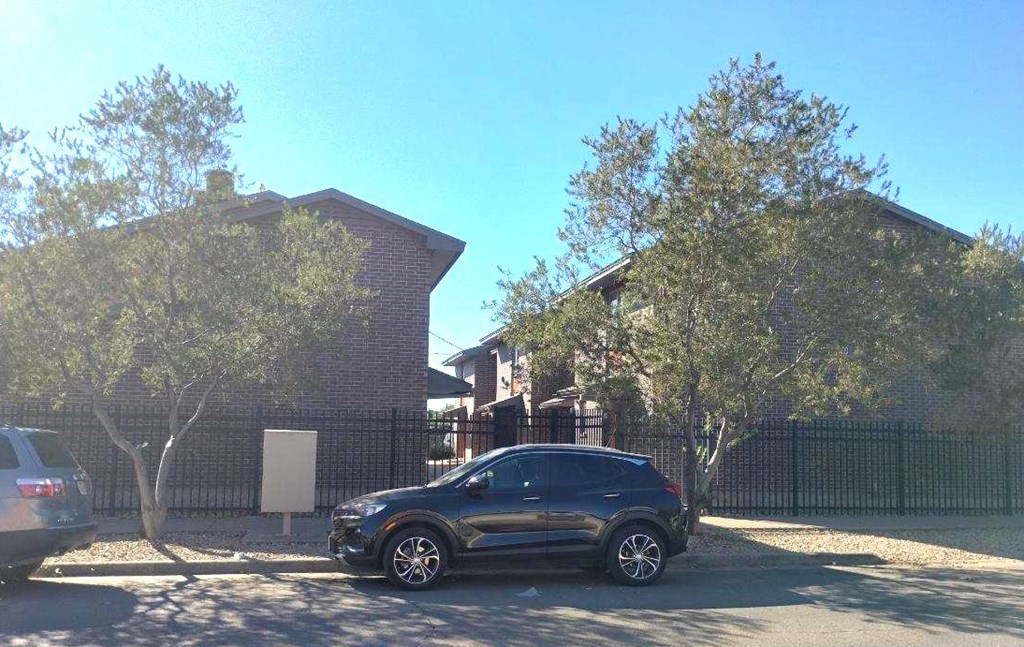 A black SUV is parked in a driveway in front of a house.