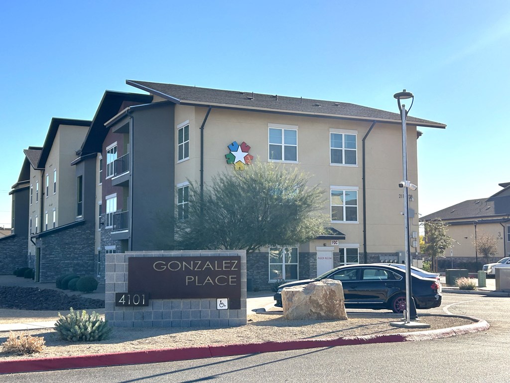 Gonzalez Place apartment complex with a car parked in front.