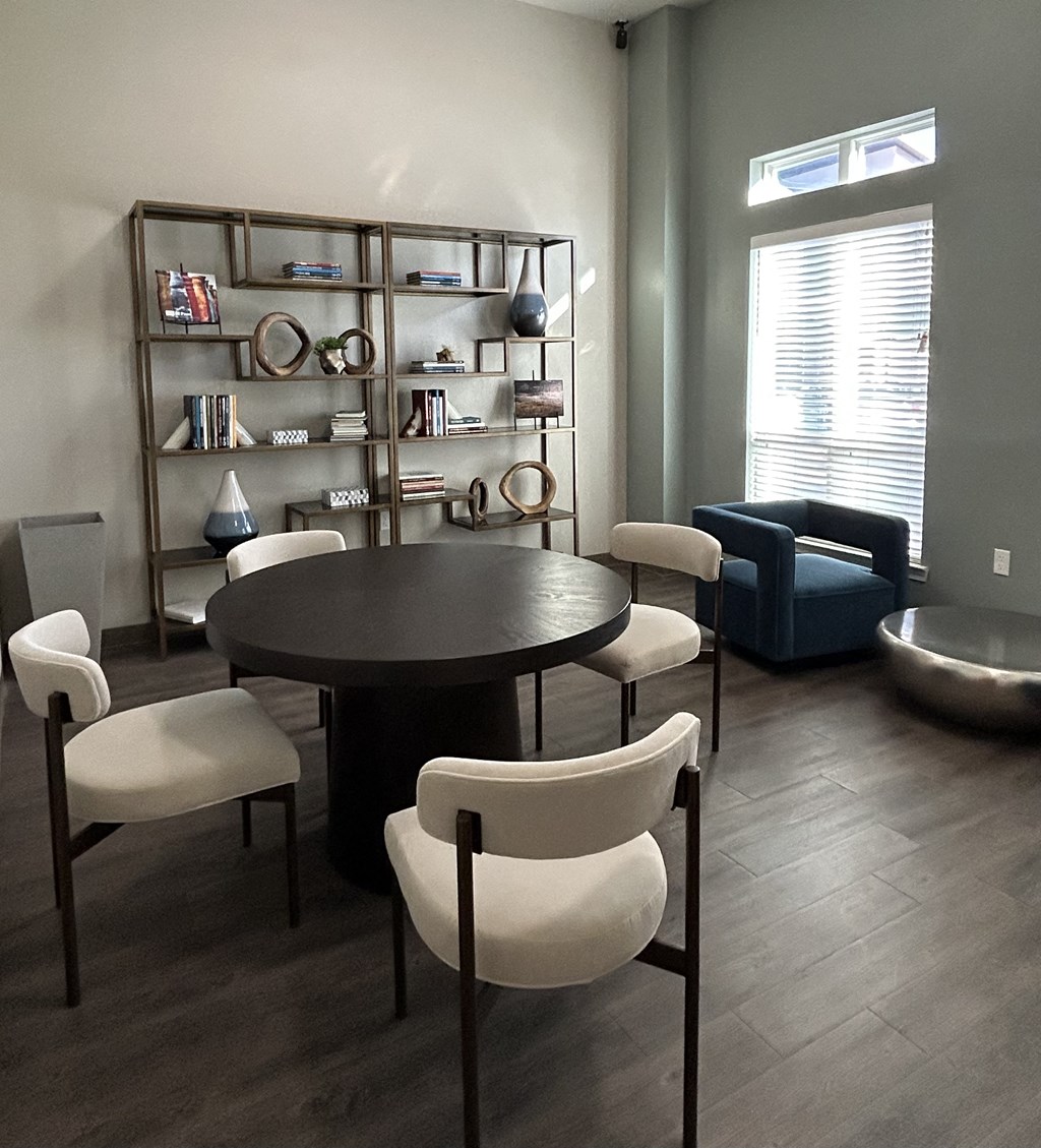 A dining room with a round table and chairs.